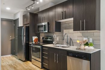 a kitchen with dark wood cabinets and stainless steel appliances